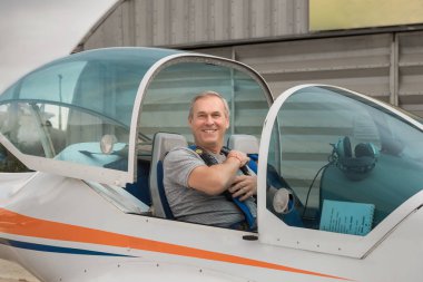 Yaşlı adam hafif uçak sürmeyi öğreniyor. Pilot eğitim kursu. Hafif uçakla uçuş