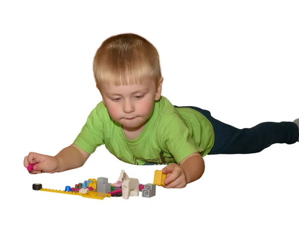 Little boy plays with colored cubes, builts a city. Portrait — Stockfoto