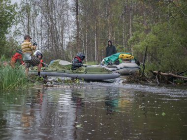 Karelia 'daki kunduz barajından geçen vahşi, dar bir nehir boyunca rafting yapmak. Su turizmi. Ekoloji, kırılgan, el değmemiş ve nispeten el değmemiş doğal alanları ziyaret etmek.