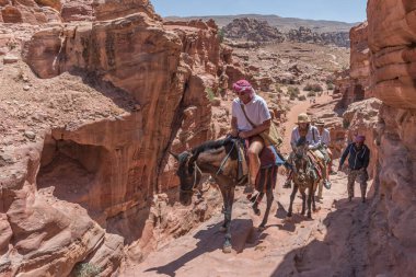 Petra, Ürdün - 23.04.2018: Ürdün 'ün Petra kentindeki Ad-Deir Manastırı' na eşeğe binen turistler. Seyahat tipi fotoğrafçılığı