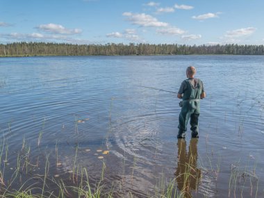 Gölde dönen bir adam. Ekoloji, kırılgan, el değmemiş, bozulmamış doğal alanları ziyaret etme. Karelia 'da aktif tatil