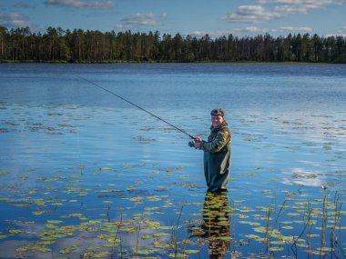 Karelia, Vodlozero - 29.07.2019: Gölde dönen genç adam. Ekoloji, kırılgan, el değmemiş, bozulmamış doğal alanları ziyaret etme. Karelia 'da aktif tatiller. Portre