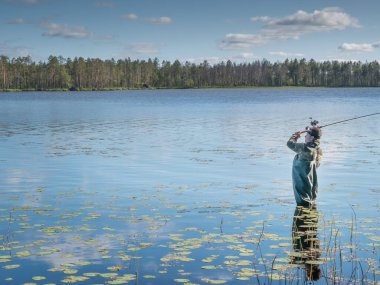 Karelia, Vodlozero - 29.07.2019: Gölde dönen genç adam. Ekoloji, kırılgan, el değmemiş, bozulmamış doğal alanları ziyaret etme. Karelia 'da aktif tatil
