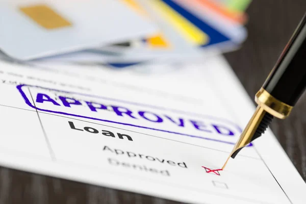 Loan application close up shot and stamp approved, cards and pen. — Stock Photo, Image