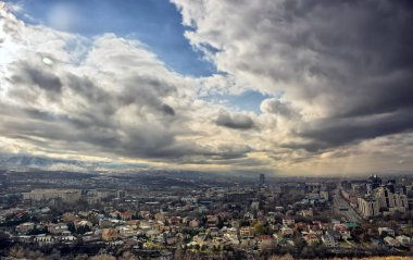 Almatı şehir üzerinde bulutlar dağ Koktyube göster.