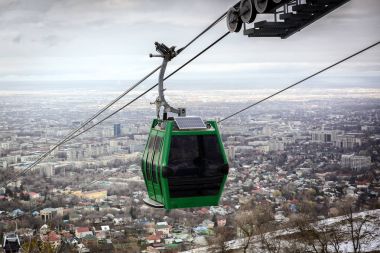 Teleferik taksi Almatı şehir arka plan üzerinde.