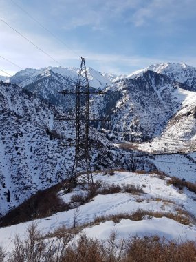 Kışın dağlarda elektrik hatları olan manzara.