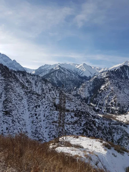 Kışın dağlarda elektrik hatları olan manzara.