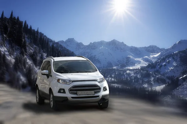Bulanık doğal arka planda Ford EcoSport beyaz arabası.