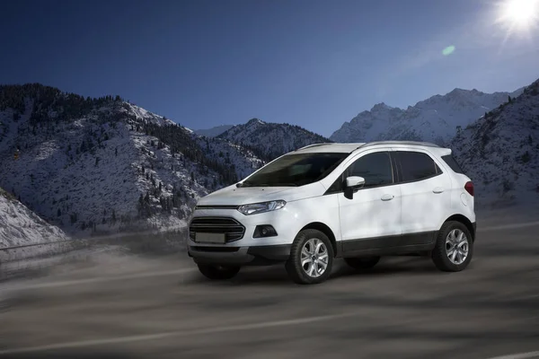 Bulanık doğal arka planda Ford EcoSport beyaz arabası.