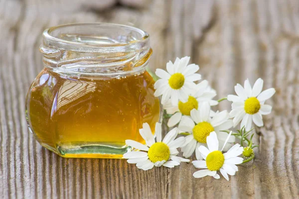 Tarro de miel y flores de manzanilla —  Fotos de Stock