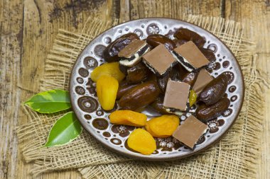 kurutulmuş meyve ve çikolata ahşap arka plan üzerinde bir plaka üzerinde