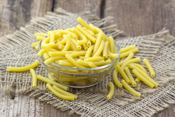 Raw pasta, maccheroni in a bowl — Stock Photo, Image