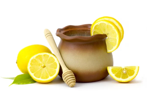 Clay pot with honey and fresh lemons — Stock Photo, Image