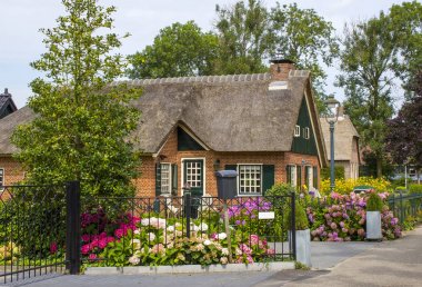 GIETHOORN, NETHERLANDS - evlerin ve bahçelerin tipik Hollanda ilçesi