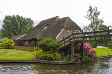 GIETHOORN, NETHERLANDS - evlerin ve bahçelerin tipik Hollanda ilçesi