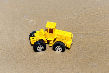 Oyuncak traktör ıslak kum. Yaz tatili denizde. Özel minyatür.