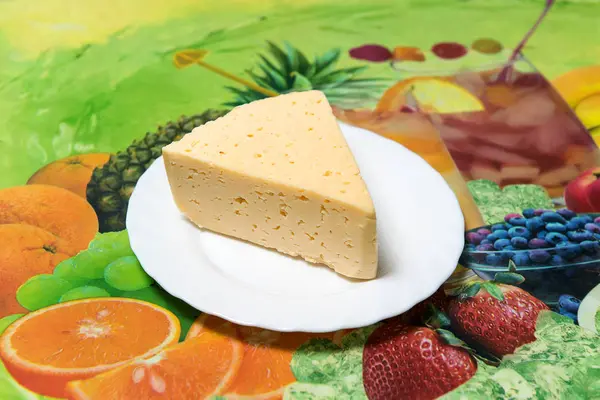 Um pedaço de queijo na mesa da cozinha — Fotografia de Stock