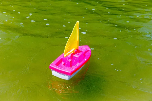 Barco de juguete en la arena mojada del mar. Vacaciones de verano en el mar. Paseos en barco . —  Fotos de Stock