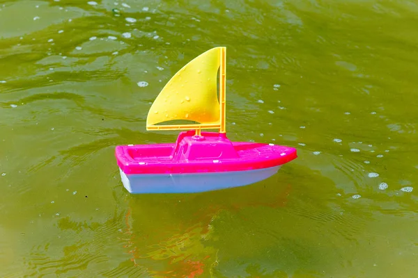 Barco de juguete en la arena mojada del mar. Vacaciones de verano en el mar. Paseos en barco . —  Fotos de Stock