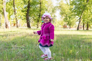 Çocuk, küçük bir kız bir karahindiba üzerinde üfleme. Baharda Parkta yürümek. Çocukluk.