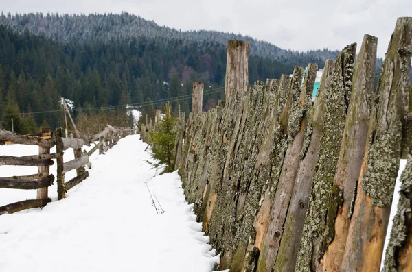 Alter ländlicher Zaun ergänzt die Winterlandschaft. — Stockfoto