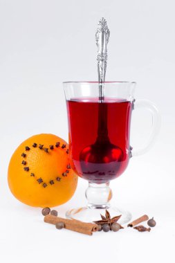 Elma ve portakal, karanfil ve vanilya ile sıcak mulled şarap yığını beyaz bir arka plan üzerine yapışır. Sıcak Noel içecek.