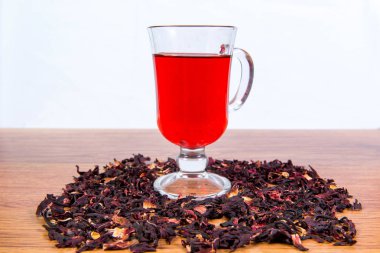Bir bardak çay gülhatmi çiçekler ve gül yaprakları sudan gelen bir tablo yakın çekim dağınık.