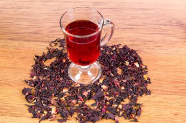Bir bardak çay gülhatmi çiçekler ve gül yaprakları sudan gelen bir tablo yakın çekim dağınık.