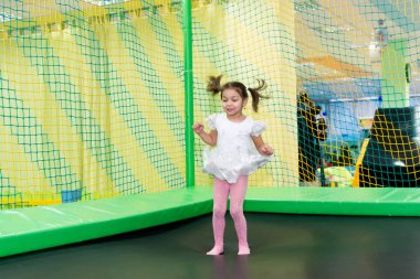 Bir trambolin üzerinde atlama doğum günü eğlence kız. Neşeli ve tasasız çocukluk.