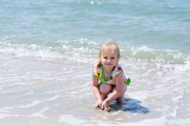 Bir çocuk, eğlenceli yaz aylarında deniz kıyısı üzerinde oynayan küçük bir kız.