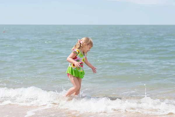 Een kind, een meisje leuk spelen aan de kust in de zomer. — Stockfoto