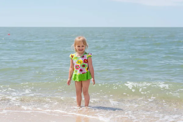 Een kind, een meisje leuk spelen aan de kust in de zomer. — Stockfoto