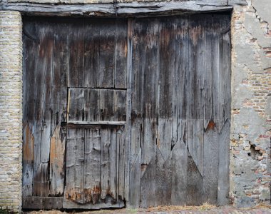 Eski, kirli ve yıpranmış kapalı ahşap ahır kapısı