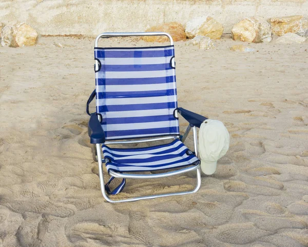 Silla y gorra en la playa de arena —  Fotos de Stock