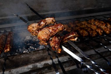 Biftek kebabı ızgaranın üstünde, duman içinde.