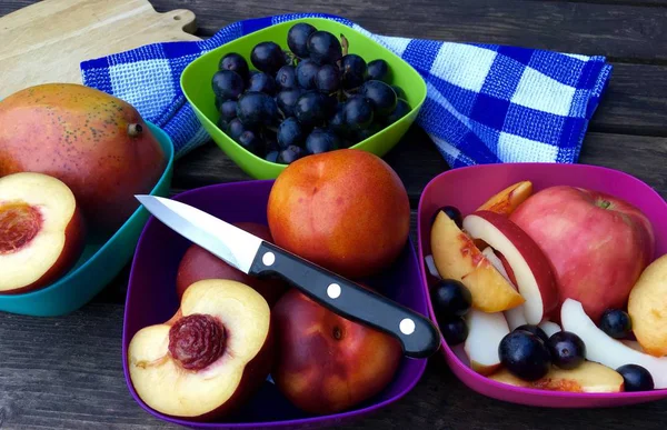 Frutas frescas con manzanas, nectarinas y uvas en cuencos coloridos — Foto de Stock