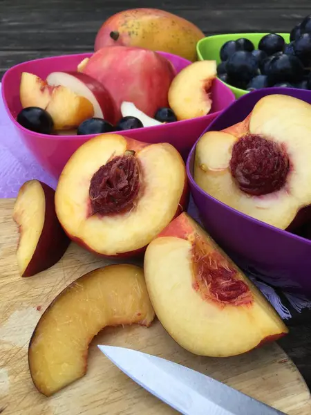 Frutas frescas con manzanas, nectarinas y uvas en cuencos coloridos — Foto de Stock