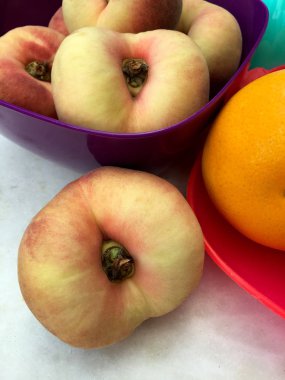 Frische Plattpfirsiche und Apfelsinen 