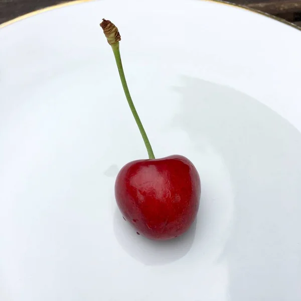 Vista de ángulo alto de una cereza fresca en un plato blanco — Foto de Stock