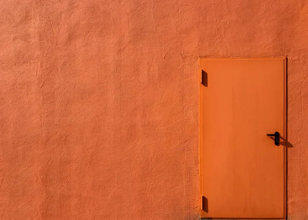 Concrete wall with door in bright orange