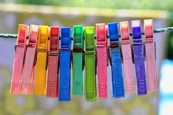 Colorful group of very old and used clothespins on a rope — Stock Photo, Image