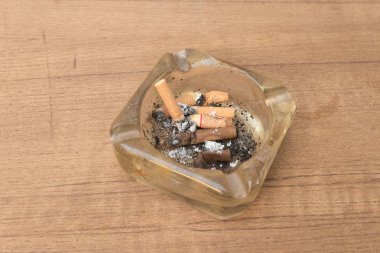 ahşap masa üzerinde bir kül tablası ile sigara, birçok sigarasını filtre