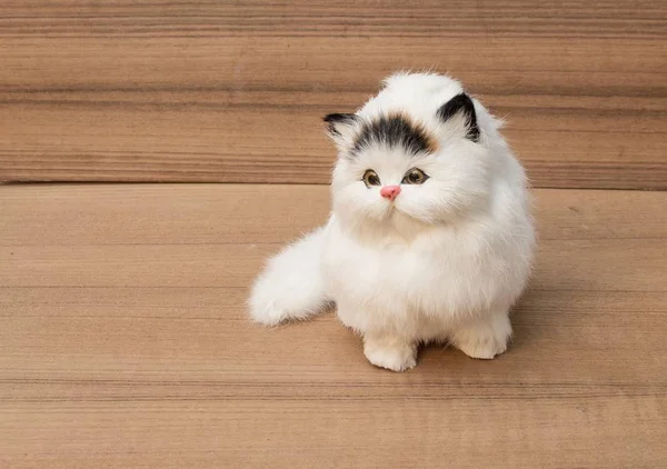 Кукла белый кот на деревянном фоне — стоковое фото