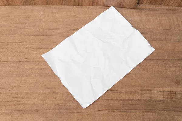 Hoja de papel blanco, bola de papel arrugado, sobre un fondo de madera — Foto de Stock