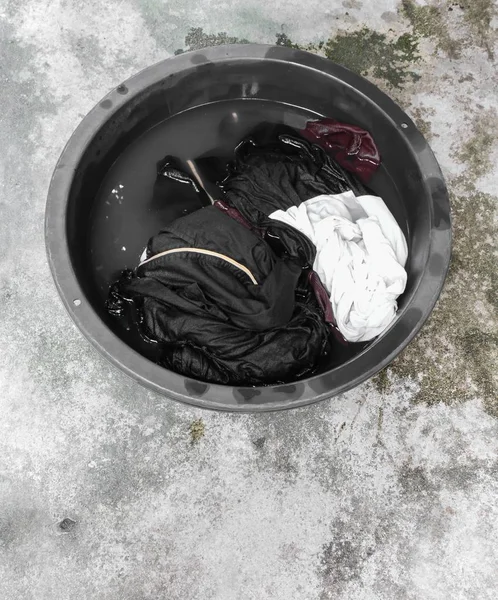 Zur Reinigung schmutzige Kleidung im Waschbecken schwarz einweichen — Stockfoto