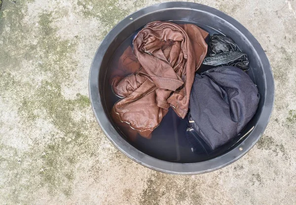 Moczyć brudne ubrania w dorzeczu czarny dla oczyścić z bliska — Zdjęcie stockowe