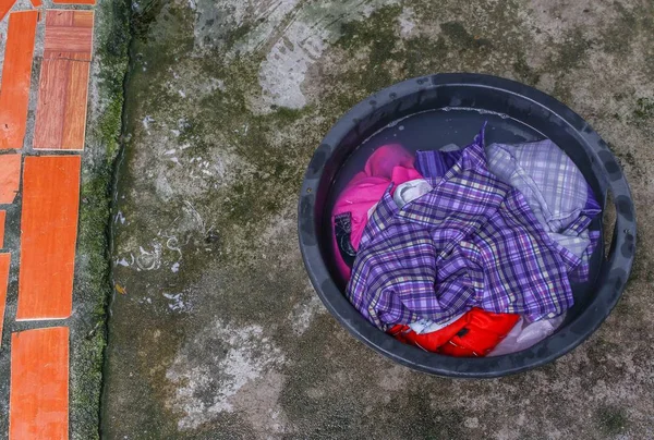 Soak dirty clothes in the basin black for cleanse — Stock Photo, Image