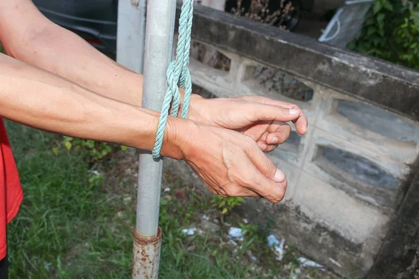 Hands tied up with rope, male with post steel hands tied  rope