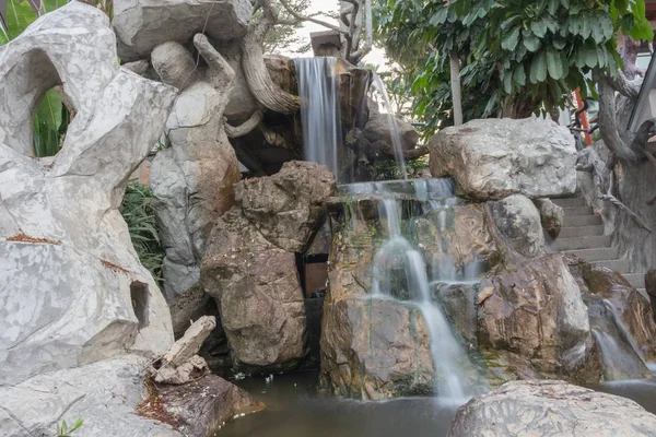 Płynne ruchy wodospad na kamień w ogrodzie piękne — Zdjęcie stockowe